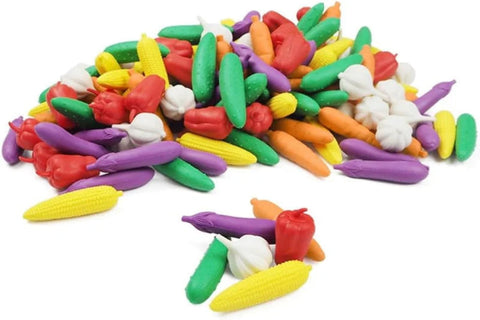 Assorted colorful plastic vegetable toys on a white background