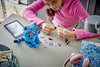 Girl building the LEGO KPop Demon Hunters Derpy Tiger set at a desk, using the LEGO Builder app on a tablet
