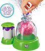 Doctor Seuss DIY Squishy Maker toy set with a green and purple base, a clear dome, and a pink glittery ball inside, shown with a hand inserting a small piece and a separate green-and-purple accessory container on a white background.