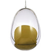 A modern egg-shaped hanging chair with a clear transparent shell, a silver metal rim, and a mustard yellow cushion inside, suspended by a chain against a white background.