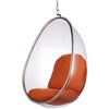 Clear hanging egg chair with orange cushioned seat and backrest, suspended by a metal chain with a silver frame, shown on a white background.