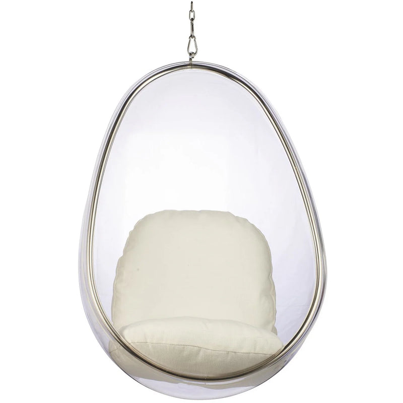 A modern egg-shaped hanging chair with a clear transparent plastic shell, a silver metal frame, and a thick cream-colored cushion inside, suspended by a chain against a plain white background.