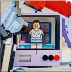 Olivia Rodrigo minifigure in a cheerleader outfit standing inside the TV screen of the LEGO Secret Storage set
