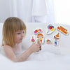 Child arranging Birthday Party foam pieces on the side of a bath, including a cake, balloons and party guests