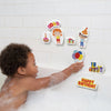 Child placing a balloon-shaped foam piece on the tiled bath wall beside birthday characters, presents and decorations