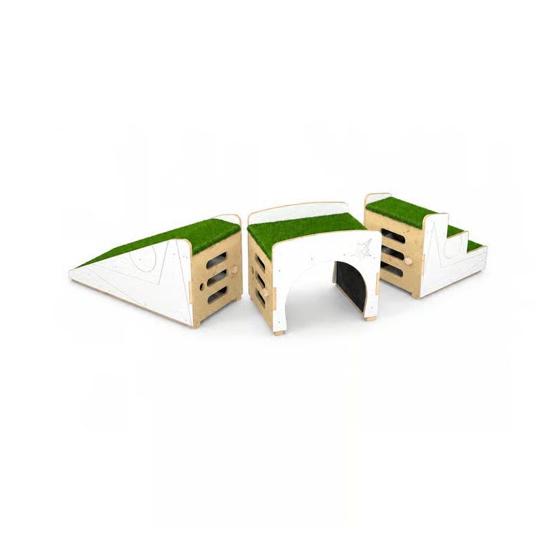 A modular wooden play structure set on a plain white background, featuring a green grass-like top surface, white side panels, and a central tunnel opening.