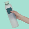Hand holding a water bottle with a Speks Slabs Mesh Green sensory sticker attached
