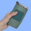 Hand holding a green tumbler with a Speks Slabs Mesh Green sensory sticker attached
