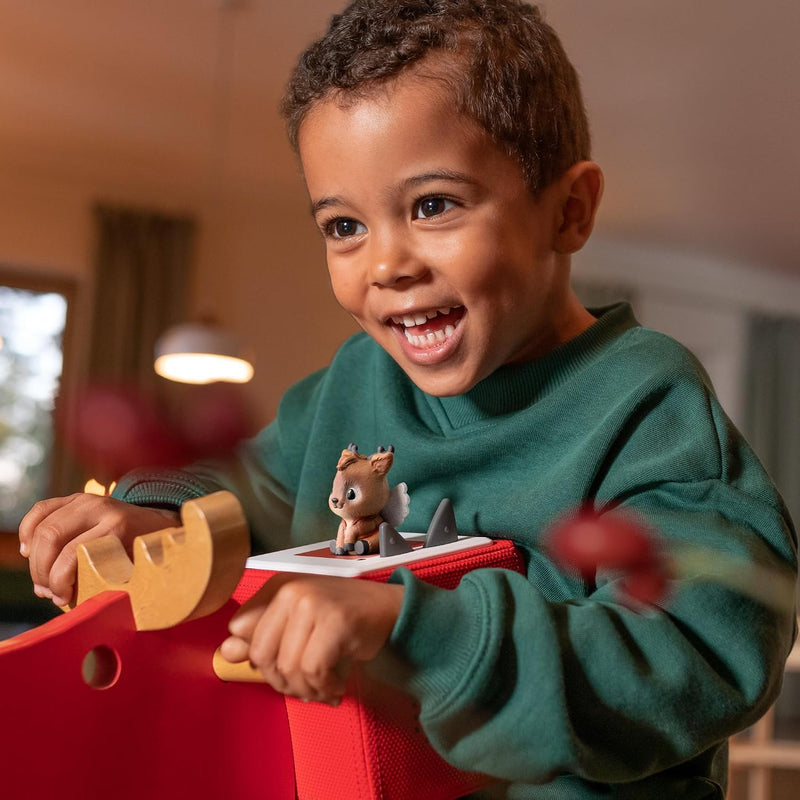 Child enjoying The Little Reindeer’s Christmas Wish Tonie on a red Toniebox