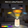 A Vtech glow-on-ceiling projection night light shown in a dim nursery setting, projecting colorful celestial designs like a sun, moon, stars, and planets onto the wall. Text highlights glow-on-ceiling projection and customizable colors.